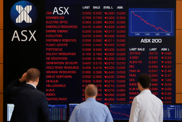 Traders monitor ASX stock market screens as technology stocks lead declines